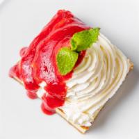 Cheesecake · Cheesecake whipped cream and strawberry sauce on top.