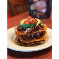 Tostada Stacker · Three tostadas layered between refried beans, your choice of seasoned grilled pork, braised ...
