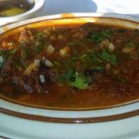Birria · Shredded lamb meat covered in a spicy red sauce, topped with cilantro and onions. Little spi...