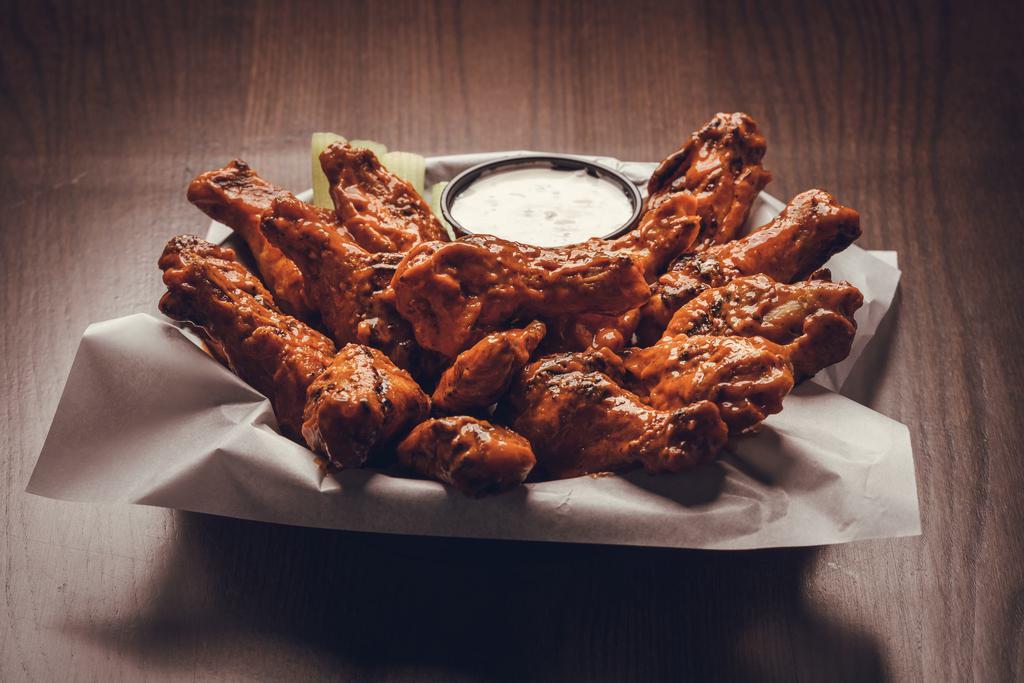 Smoked Wings · Hardwood smoked bone-in wings finished char-broiler or trashed (Smoked & Fried) then tossed in your choice of wing sauce or dry rub w/ bleu cheese or ranch & celery sticks.