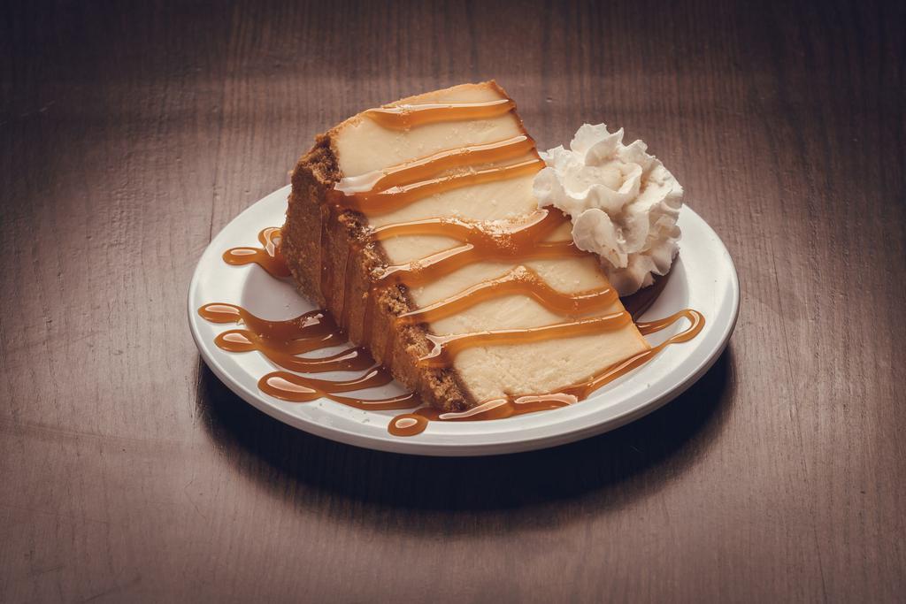 Salted Caramel Cheesecake · A colossal slice of New York cheesecake topped w/ salted caramel sauce and whipped cream. 
