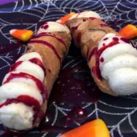 Casper Cannoli · 2 ghost cookie dough filled cannoli with Dracula blood and candy corn.