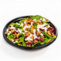 Spinach Salad · Fresh baby spinach, dried cranberries, candied walnuts, and aged feta. Served with one dress...