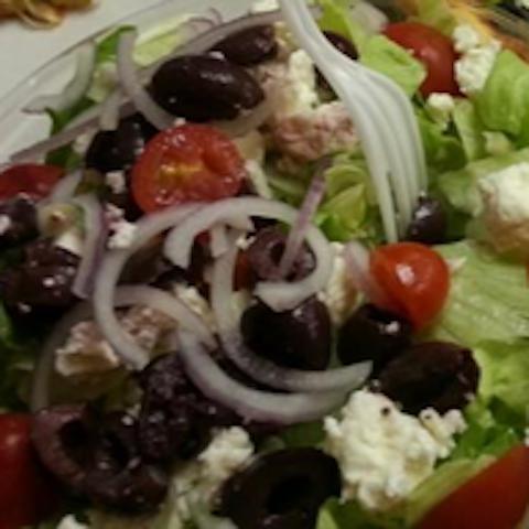 Greek Salad · Iceberg lettuce, red onions, Kalamata olives, cherry tomatoes and feta cheese with Caesar dressing.