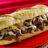 Philly Cheesesteak Deluxe · Served with lettuce, tomatoes, french fries,  and pickle.