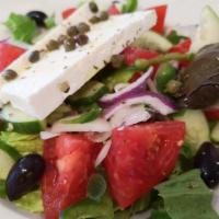 Greek Salad · Served with lettuce, tomatoes, onions, peppers, cucumbers, olives, feta dodonis, and bay lea...