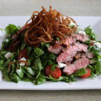 Steak Salad · Grilled flat iron steak served over arugula with goat cheese, tomatoes and red onion in a ba...