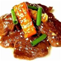 Korean Beef · Thin slices of marinated beef on a sweet and spicy sauce with carrots and  chayote topped w/...