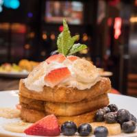 Cap'N Crunch French Toast · Topped with Banana, Mixed Berries, Whipped Cream, Cinnamon, and Powdered Sugar. Served with ...