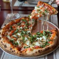 Margherita Pizza · Fresh mozzarella, sliced tomatoes, basil, garlic and olive oil.