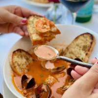 Cioppinoe E Crostini · Manila clams, mussels, calamari, fresh fish and shrimps in a garlic tomato broth.