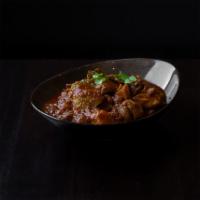 Burmese Style Chicken Curry · Chicken thighs simmered in lemongrass, onions, ginger, garlic, masala, paprika, potato, turm...