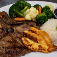 Grilled T-Bone Steak · T-bone steak, grilled jumbo shrimp, served with rice, and beans.