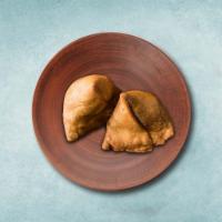 Vegetarian Samosa  · Indian pastry filled with potato, peas, and Indian spices. Served with a side sauce.
