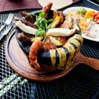 Molcajete Santiago · Grilled chicken, grilled steak and grilled shrimp served in a special sauce. Served with ric...