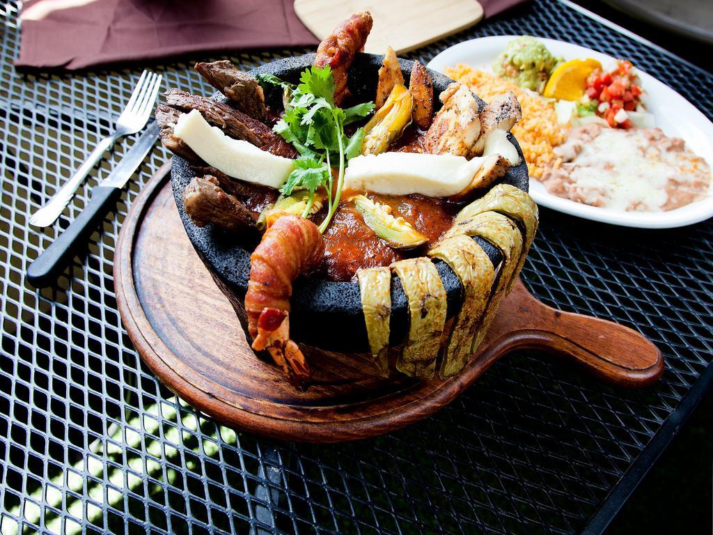 Molcajete Santiago · Grilled chicken, grilled steak and grilled shrimp served in a special sauce. Served with rice and beans on a separate plate.