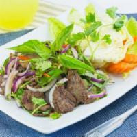 37. Beef Salad · Beef tossed with lime juice, chili, onion, mint leaves and rice powder. Hot and spicy.