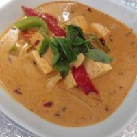 67. Red Curry · With sliced bamboo shoot, basil leaves, bell pepper, zucchini, red curry paste and coconut m...