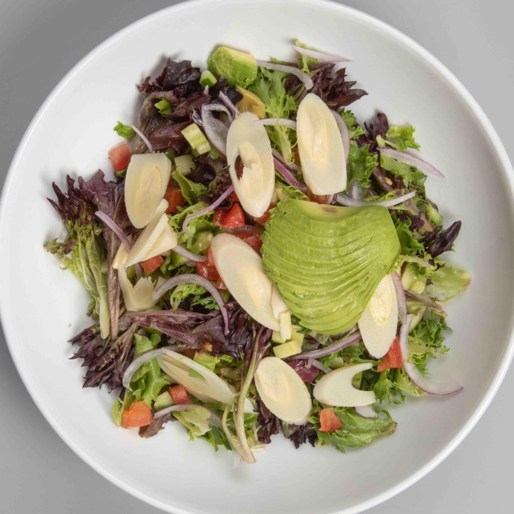 Ensalada Criolla · Criolla salad. Homemade dressing, tomatoes, avocado, red onions, hearts of palm and chopped cilantro.