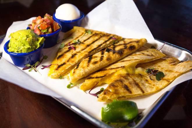 Grilled Quesadilla · Grilled flour tortilla filled with cheddar cheese. Served with a side of guacamole, sour cream, and salsa.