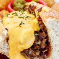 Philly Cheesesteak · Shaved ribeye steak with caramelized onions, melted provolone cheese and brewskis cheese sau...