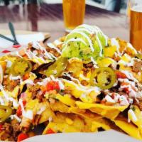 Nachos · Made to order tortilla chips, covered with cheddar cheese, carne or pollo, and topped with g...