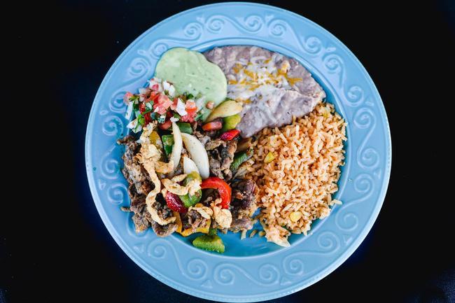 13. Fajitas chicken and steak · Grilled fajita veggies with grilled chicken and steak full of flavor garnished with lettuce, pico de gallo and shredded cheese. 
Served with rice, beans and a side of tortillas.