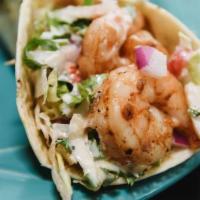 Shrimp Taco · Grilled shrimp taco served in a flour tortilla filled with cabbage, red onions, cilantro, pi...
