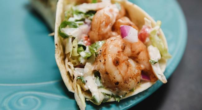 Shrimp Taco · Grilled shrimp taco served in a flour tortilla filled with cabbage, red onions, cilantro, pico de gallo, and jalapeno ranch