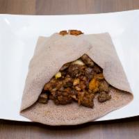12. Kuanta Firfir · Mixture of injera, sauce with onion, tomato, garlic, special dried lean beef and herbed butt...