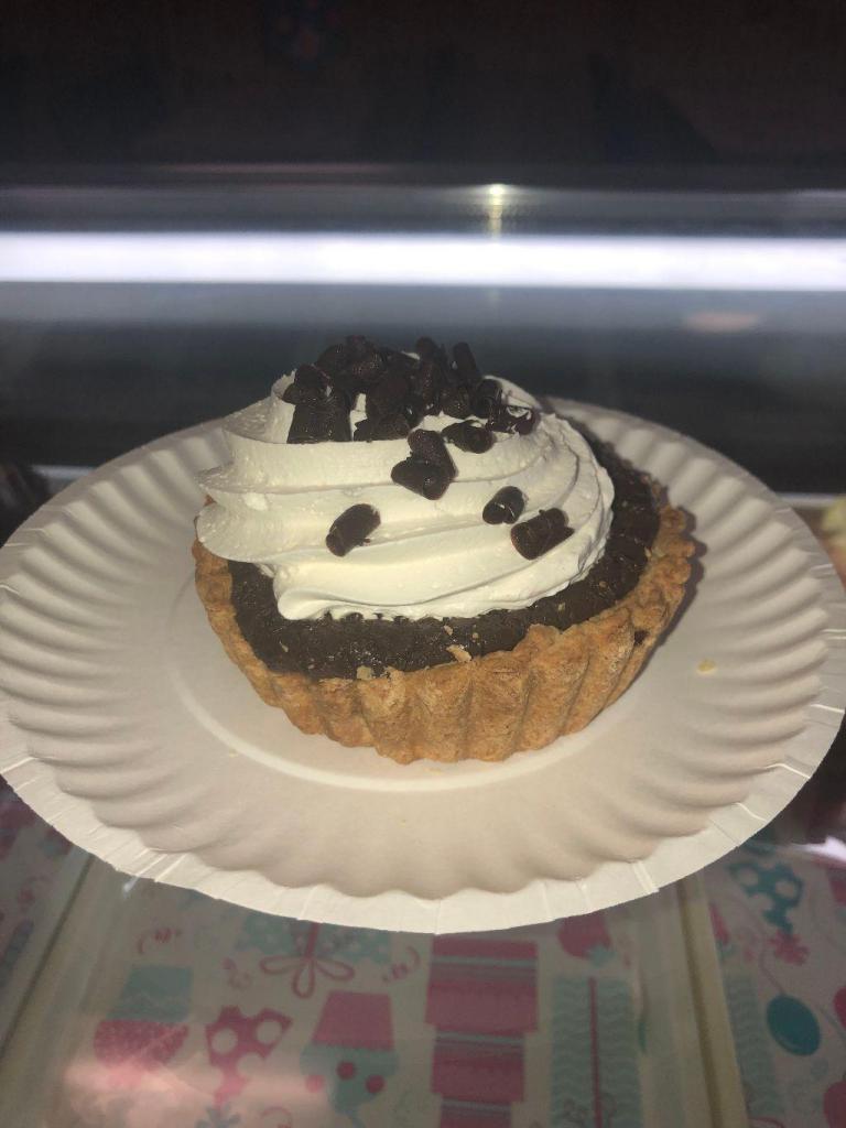 Chocolate Cream Tart · A crisp pie dough shell filled with a creamy chocolate silk, topped with whipped topping and sprinkled with milk chocolate curls.