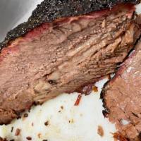 Smoked Brisket (À la Carte) · Cooked low and slow over Apple and Cherry Wood, finished off with a hint of mesquite
