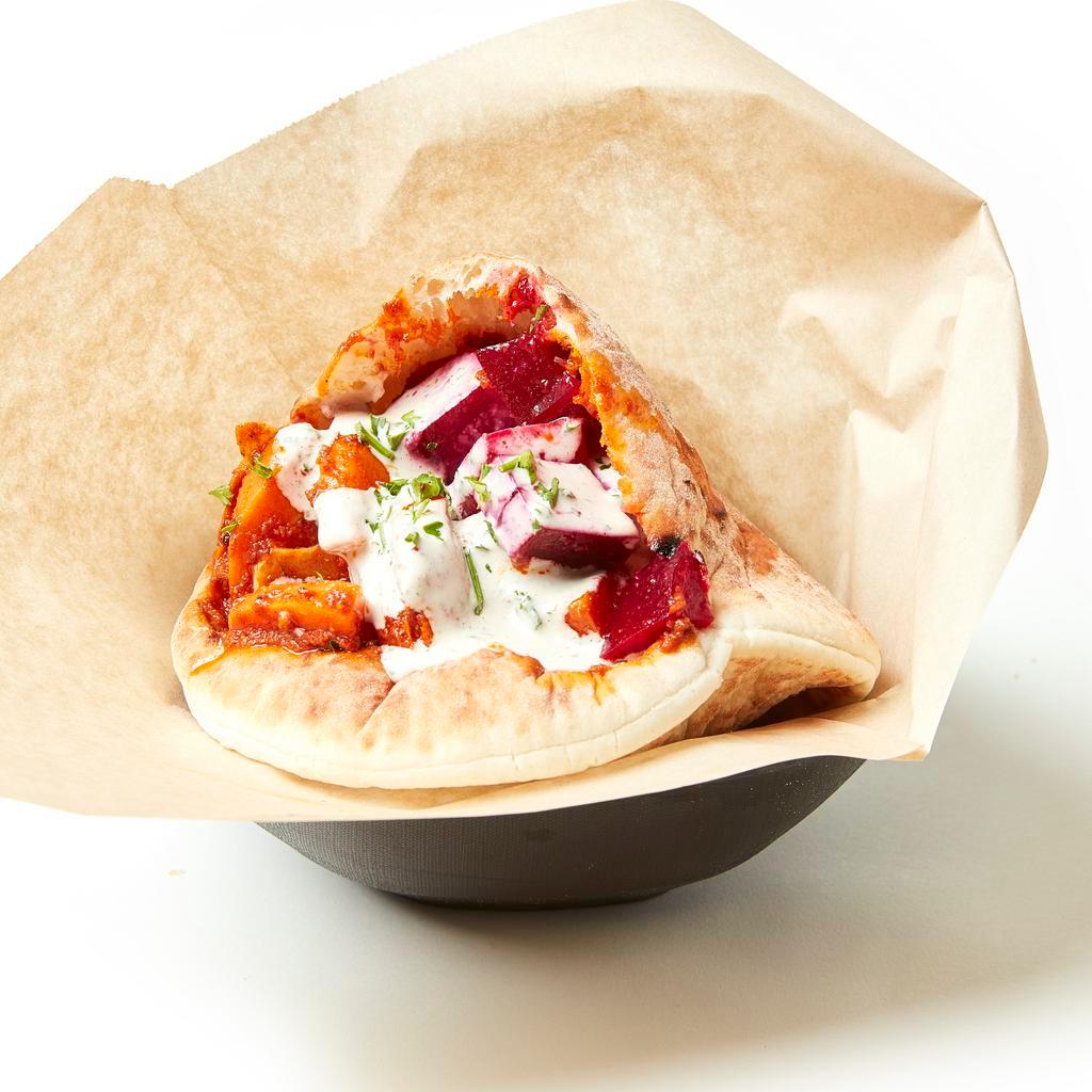 Beets & Carrots Pita · Freshly baked pita pocket stuffed with Moroccan carrots, marinated beets, hummus, israeli salad, pickled cabbage and creamy tahini sauce.  Add toppings to customize it!