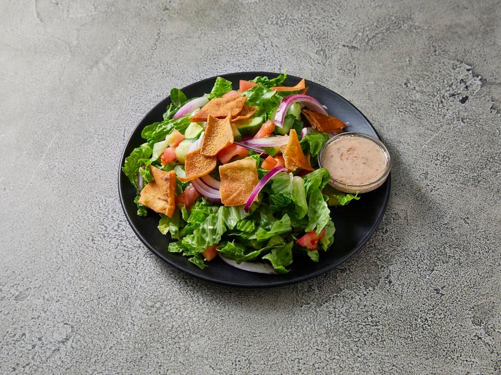 Fattoush Salad · Fresh romaine lettuce, chopped tomatoes, sliced red onions, cucumbers, and red cabbage. Tossed with crispy pita chips and our house-made fattoush vinaigrette dressing.