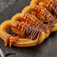 CHURROS · Crispy churros with Nutella and Dulce de leche.