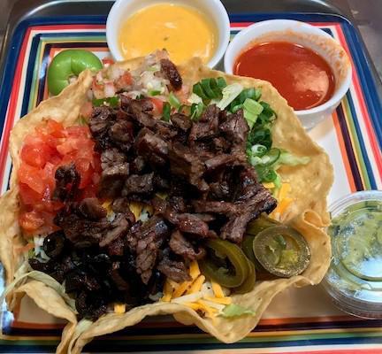 Steak taco salad · Tortilla bowl shell filled with fresh cut lettuce choice of beans and protein. Tomatoes, black olives, jalapeños peppers, pico de gallo,cheese medley Monterrey jack and cheddar, sour cream, and guacamole.