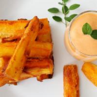 YUCAS A LA HUANCAINA · Fried cassava pieces with Peruvian yellow pepper and cheese sauce on the side.