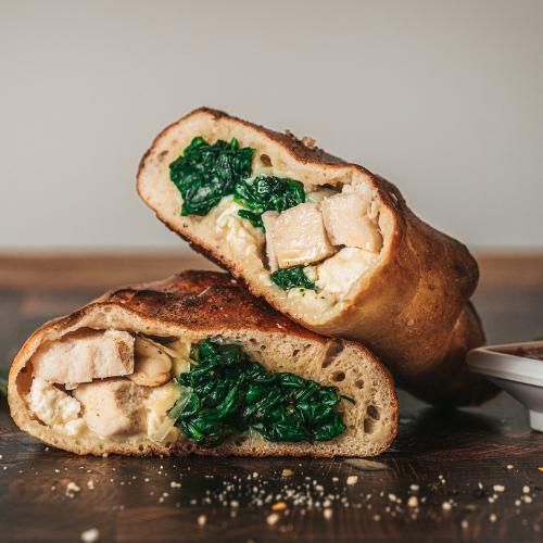 Chicken Feta and Spinach Calzone · Here we have roasted chicken, spinach with feta and mozzarella cheese, finished with some parmesan. We serve this beautiful creation with a side on house marinara sauce.