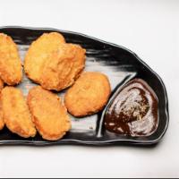 Connoisseur’s Chicken Nuggets · Farm chicken breasts battered and lightly fried until golden crisp. Served with hot sauce.