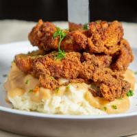 Buttermilk Fried Chicken · Boneless chicken thighs battered served atop a bed of whipped potatoes, smothered in country...