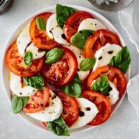 Caprese · Mozzarella, tomatoes, pesto, and arugula 