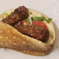 Kofta (Adana) · New! Homemade pita bread, hummos sauce, lettuce, tomato, onion, and kosta meat.