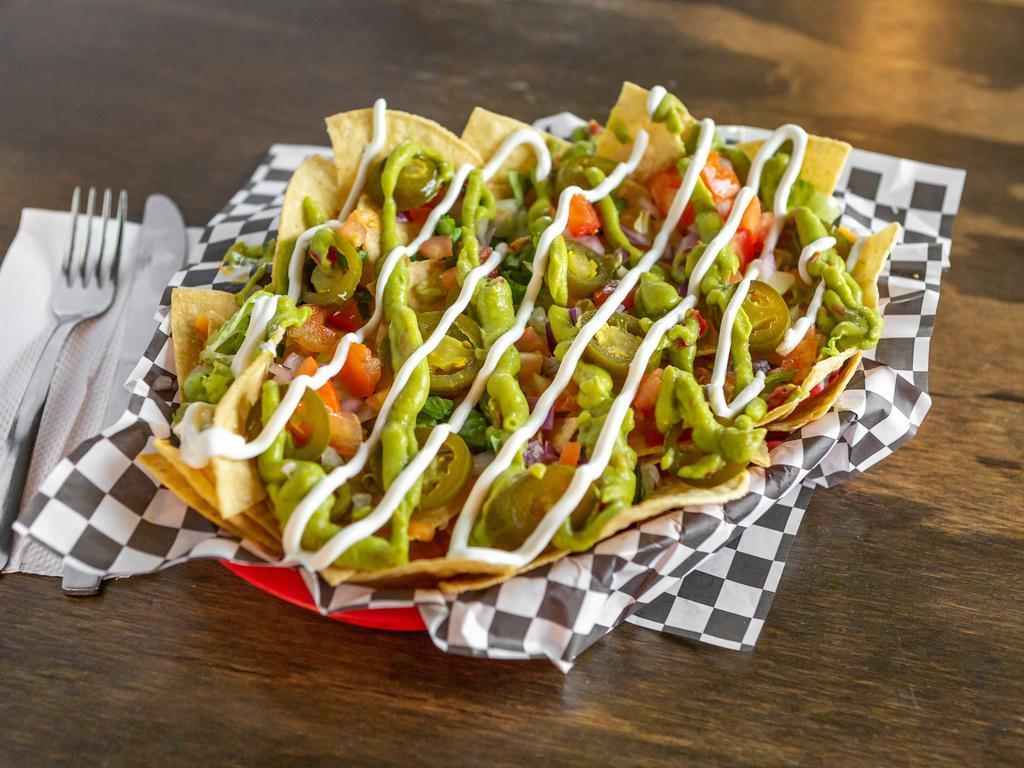 Nachos  ·  A bed of tortilla chips, stacked with Monterey Jack, shredded lettuce, onion, tomato, guacamole, and jalapenos. Add chicken and beef for an additional charge. 