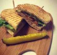 Club Panini · Bacon, ham, turkey, provolone cheese, lettuce, tomatoes, and a pickle wedge.