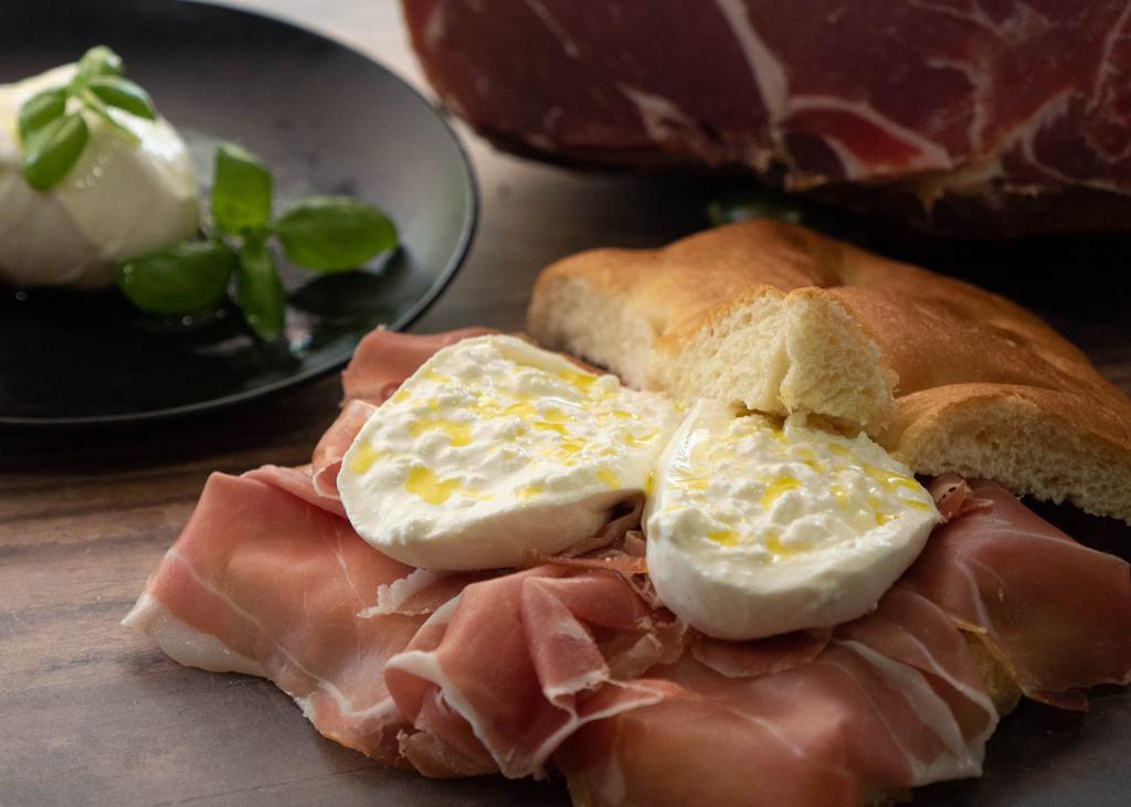 Parma Prosciutto Focaccia · Oven-baked focaccia stuffed with freshly cut 24 months ages prosciutto di Parma matched with entire burrata cheese. 