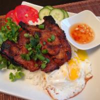 Grilled Pork Chop · A traditional rice dish. Served with green salad tomatoes and homemade sauce. 