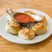 Garlic Knots · 6 homemade knots drizzled with garlic butter and served with our tomato sauce.