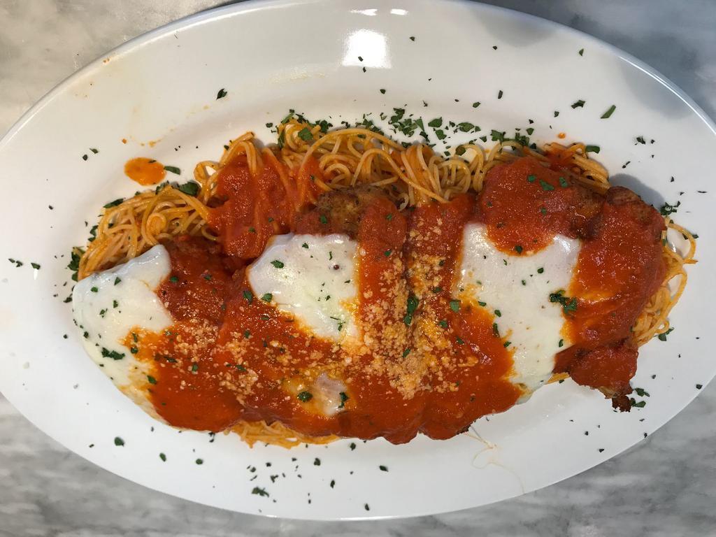 Chicken Parmigiana Dinner · Breaded and golden fried chicken breast topped with melted mozzarella cheese and tomato sauce, baked in the oven and served with capellini pasta.