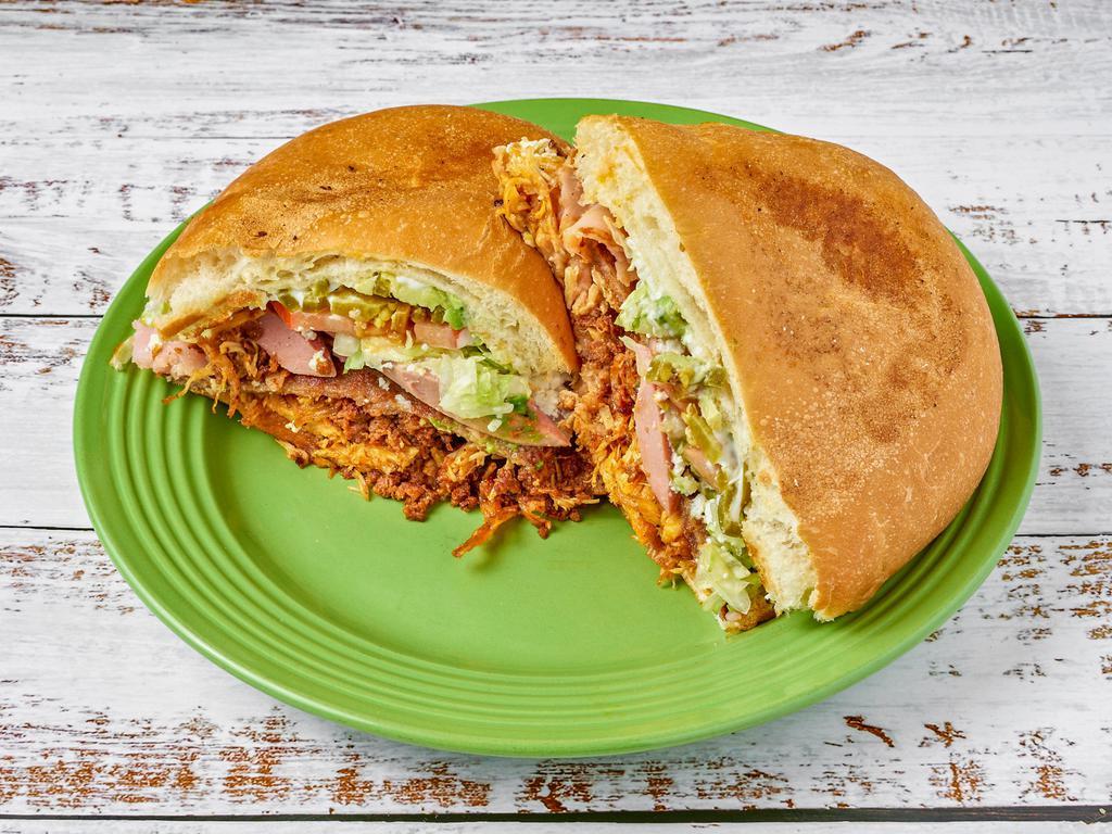 Torta Cubana · Meat-lover's sandwich with breaded beef, sausage, ham, chicken, and Mexican sausage. Topped with beans, crumbled cheese, jalapeños, tomato, lettuce, avocado, and mayo.

Torta de carnes con milanesa de res, chorizo, salchicha, pollo, y jamón. Torta con frijole, queso fresco, jalapeños, jitomate, lechuga, aguacate, y mayonesa.