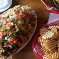 Mile-High Nachos · Folks favorite! Chips piled high with chili, cheese, lettuce, tomato, onion large enough for...